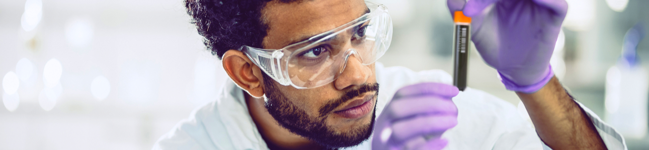 Lab technician inspecting a sample storage tube