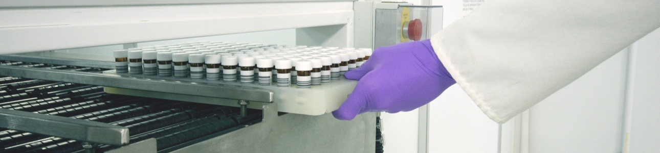 Lab technician pulling racked vials from a storage