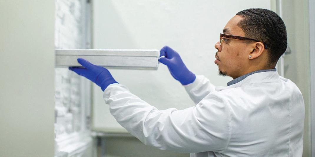 Technician pulling a rack from a freezer